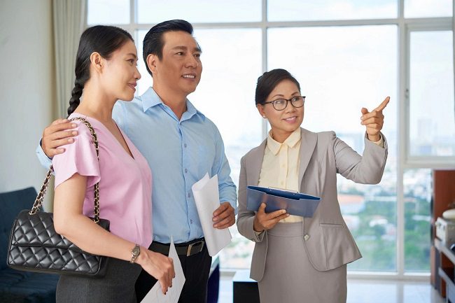 Professional estate agent showing apartment to Asian couple